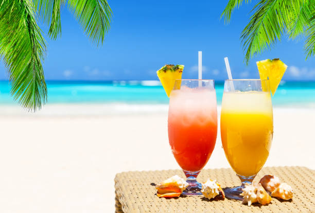 istock Two tropical fresh juices on white sandy beach 1153027710