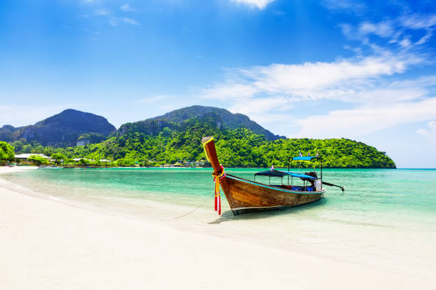 Thai traditional wooden longtail boat and beautiful sand beach. Thai traditional wooden longtail boat and beautiful sand beach at Koh Phi Phi island in Krabi province. Ao Nang, Thailand. koh poda stock pictures, royalty-free photos & images