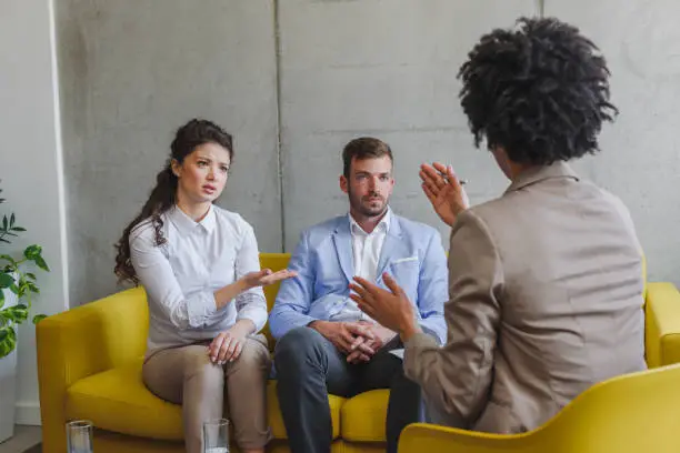 Photo of Unhappy couple arguing, having fight, disagreement at psychologists office