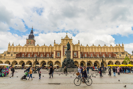 Krakow Poland. April 2019. A view of the Adam Mickiewicz Monument and Cloth Hall in the medieval old town square in Krakow. Krakow Old Town is the historic central district of Krakow, Poland It is one of the most famous old districts in Poland.The entire medieval old town is among the first sites chosen for the UNESCO's original World Heritage List.