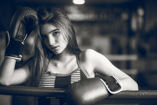 Close up of a young girl, in a boxing ring. Black and white photo.