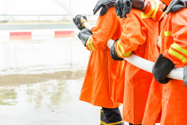 istock Firefighter using extinguisher and water from hose for fire fighting, Firefighter spraying high pressure water to fire with copy space. 1153039818