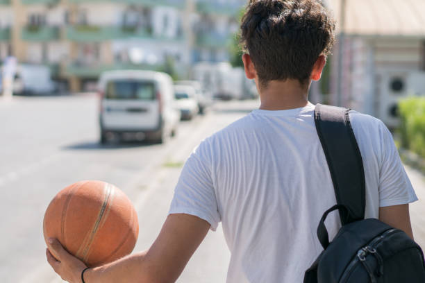 istock Basketball player walking on street wit his ball. 1153041125