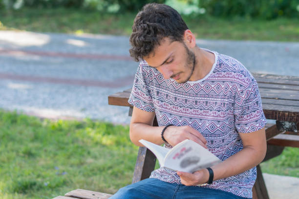 istock Men sit reading book in quiet nature, concept read a book. 1153042609