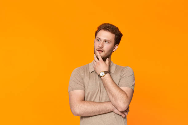 istock Young bearded confident man with hand raised on chin and looking aside. 1153042840