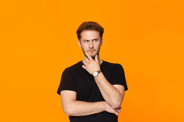 istock Young bearded confident man with hand raised on chin and looking at the camera. 1153042905