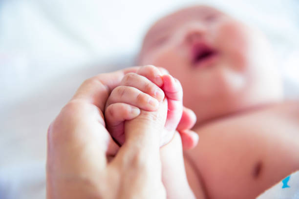 istock Newborn baby holding father's hand 1153045344