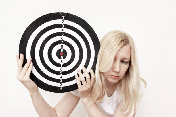 istock Woman holding a dart board in hands close up, aiming and targetting concept 1153046331