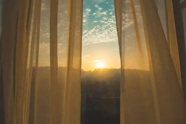 Photo of Window curtain at sunrise