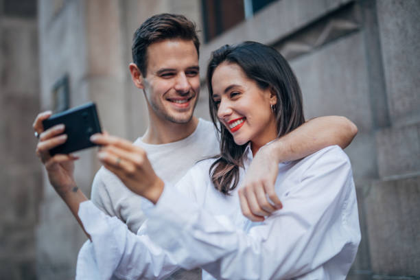 istock Couple standing outdoors and making selfie 1153048405