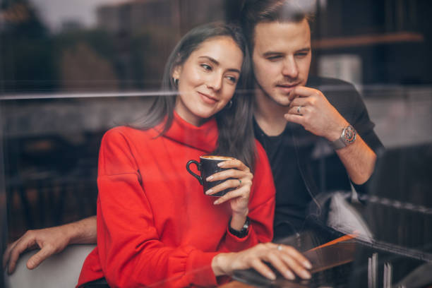 istock Beautiful couple using laptop in coffee shop 1153048463