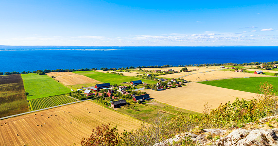 Panorama view of the magnificent rural landscape with multicolored fields leading down to Lake Vattern