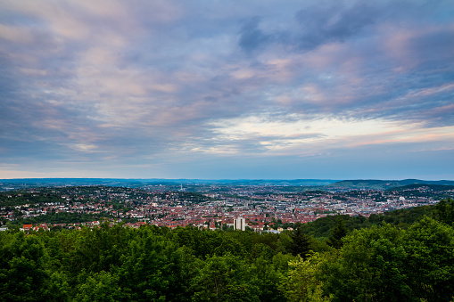 Germany, Stuttgart city metropolis of countless houses and buildings forming skyline in valley from mountain rubble at sunset