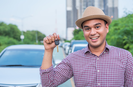 Asian man holding a car key