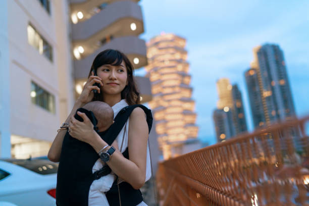 молодая азиатская китайская мать, путешествующая по городу одна с ребенком на буксире во время работы на ходу - travelogue стоковые фото и изображения