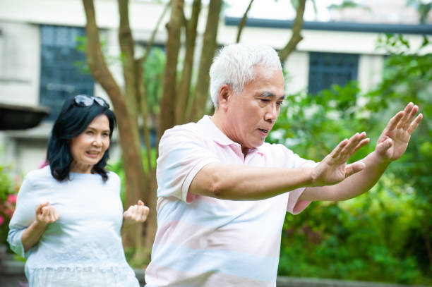 istock Senior Asian couple practicing Tai Chi in park 1153058172
