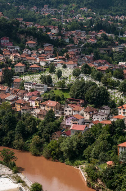 Sarajevo, Bosnia and Herzegovina, Western Balkans - July 8, 2018: aerial view of the skyline of the capital Sarajevo, surrounded by the Dinaric Alps and situated along the Miljacka River, seen from the top of Zuta Tabija (Yellow Fortress) sarajevo, bosnia y herzegovina, balcanes occidentales: vista aérea del horizonte de la capital sarajevo, rodeado por los alpes dináricos y situado a lo largo del río miljacka, visto desde la parte superior de zuta tabija (fortaleza amarilla)
