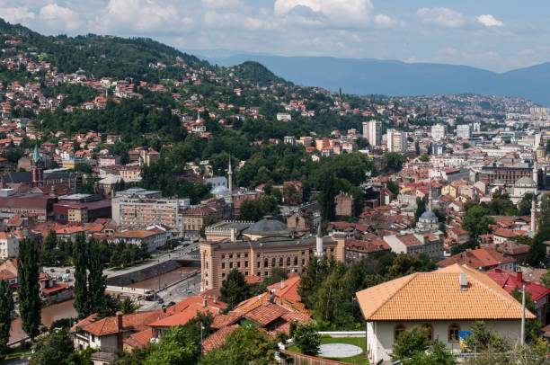 Sarajevo, Bosnia and Herzegovina, Western Balkans - July 8, 2018: aerial view of the skyline of the capital Sarajevo, surrounded by the Dinaric Alps and situated along the Miljacka River, seen from the top of Zuta Tabija (Yellow Fortress) sarajevo, bosnia y herzegovina, balcanes occidentales: vista aérea del horizonte de la capital sarajevo, rodeado por los alpes dináricos y situado a lo largo del río miljacka, visto desde la parte superior de zuta tabija (fortaleza amarilla)