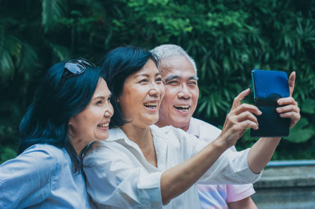 istock Senior adults having fun taking selfie in the park 1153062535