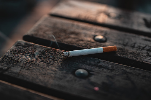 Half burnt cigarette on wooden table