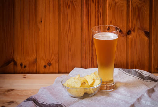 istock Light  beer with potato chips in glass bowl on  wooden table. 1153063694