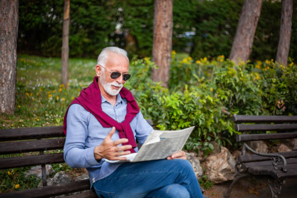 istock Senior man reading a newspaper in the park 1153067101