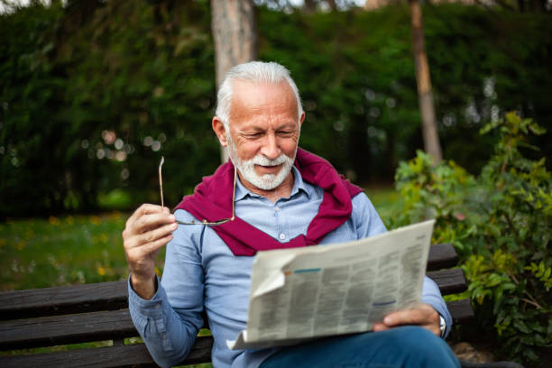 istock Senior man reading a newspaper in the park 1153067186