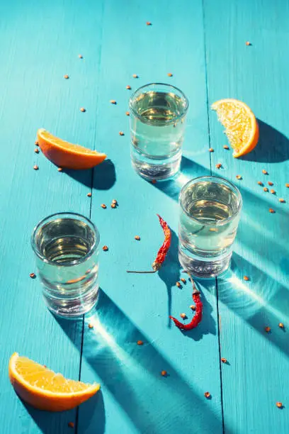 Photo of Mexican mezcal shots with slice of orange fruit