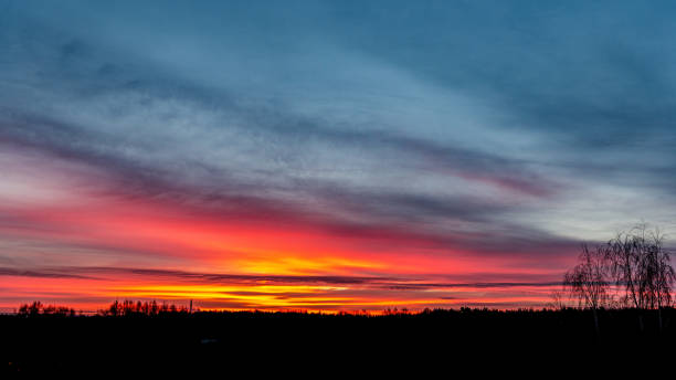 istock dramatic red sunset colors in the sky above trees and fields 1153068519
