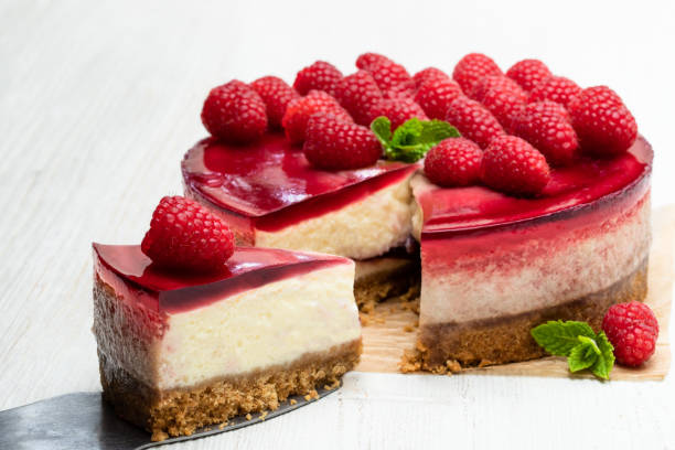 istock Homemade cheesecake with raspberry jelly on white wooden table 1153068895
