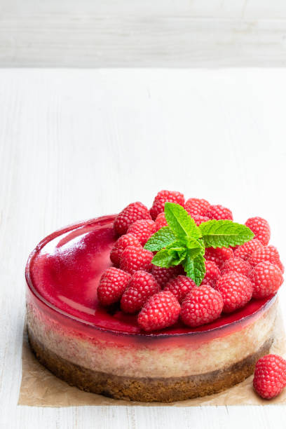istock Homemade cheesecake with raspberry jelly on white wooden table 1153068918