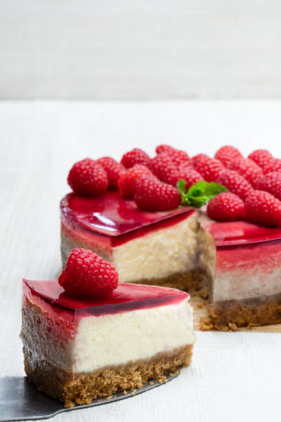 istock Homemade cheesecake with raspberry jelly on white wooden table 1153071276