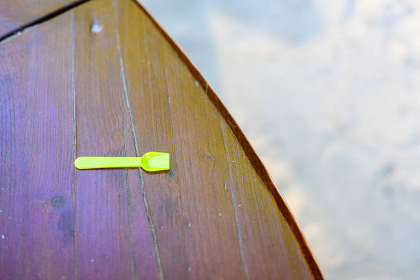Yellow plastic spoon on a brown wooden table