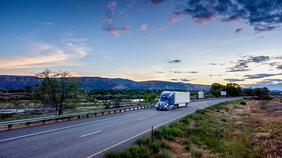 Big freight truck on the open highway in front of an amazing sunset