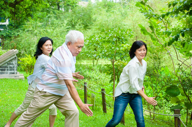 istock Senior man practicing Tai Chi with his female students in background 1153083491