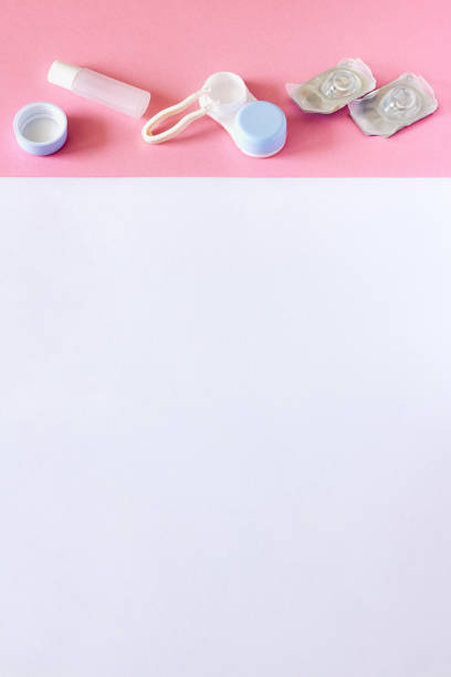 istock Contact lenses, case and accessories on pink and white background 1153084669