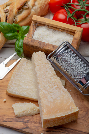 Original italian cheese, aged Parmesan cow milk cheese, pieces and grated Parmigiano-Reggiano close up