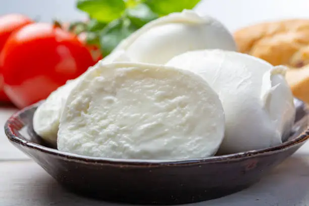 Balls and pieces of buffalo mozzarella, soft Italian scheese made from the milk of Italian Mediterranean buffalo close up