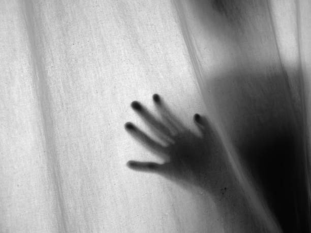 istock Screaming human pressing through fabric curtain as horror background . Trapped in shadows 1153088016