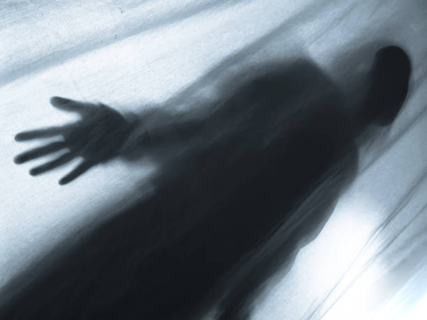 istock Screaming human pressing through fabric curtain as horror background . Trapped in shadows 1153088358