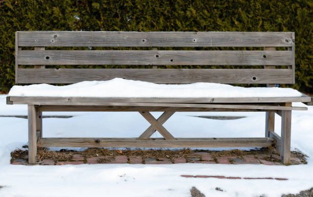 istock Old rusty  pine wood bench empty  in park  covered white snow  during winter 1153088571