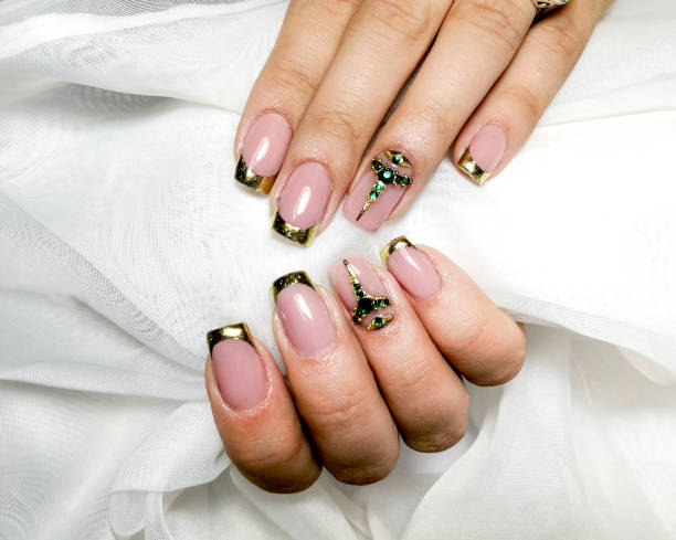 manicura de gel en oro francés con piedras semipreciosas verdes. - fingernail manicure beauty decoration fotografías e imágenes de stock