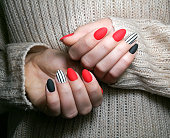 Close-up of young women with  multicolored nails gel manicure .Girl  with her hands behind.