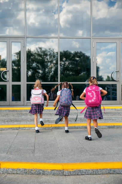 istock Group of elementary school kids running at school, back view 1153089807