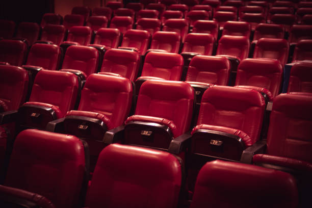 istock Red leather movie seats with lights dimmed 1153090242