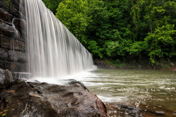 A waterfall flowing over a damn onto the rocks.