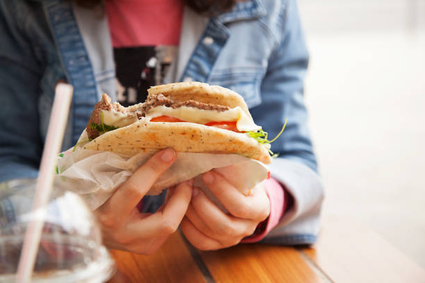 istock hands holding a hamburger on the street 1153093117