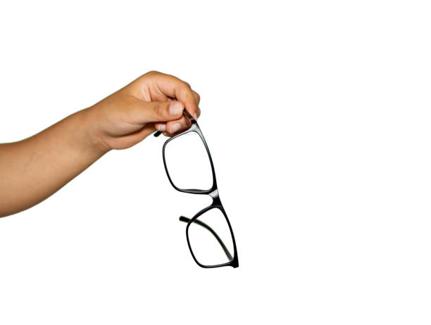 istock Eye glasses being held by fingers and hand on white 1153096640