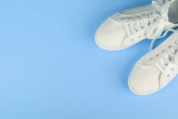 istock white sneakers on color background. copy space. 1153100337