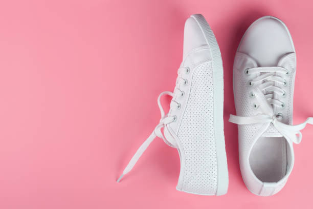 istock white sneakers on color background. copy space. 1153101002